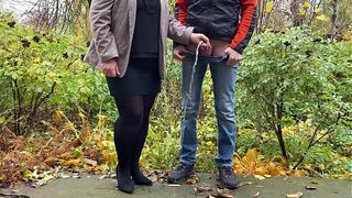 Hot mature sexy milf in pantyhose and skirt holding guy's cock outdoors while pissing